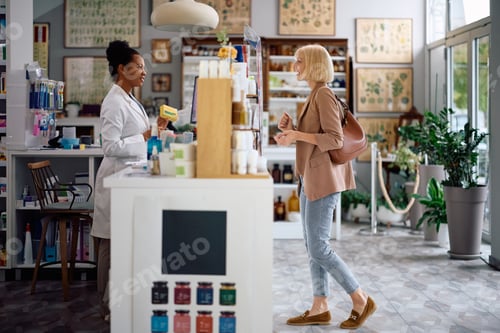 Preview: Happy black pharmacist advising her customer in choosing medicine in a pharmacy.