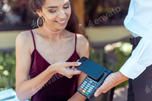Preview: Close-up view woman paying with NFC technology on smartphone