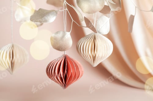 Preview: Christmas honeycomb paper decor on golden branch on beige background with textile and bokeh.