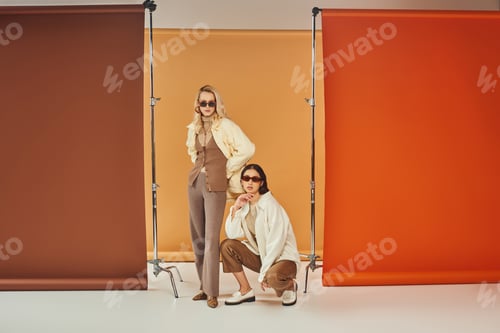 Preview: Fashionable Women Posing on Colorful Studio Backdrop