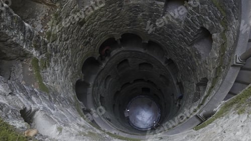 Preview: View of underground well tower. Action. Old medieval tower building underground. Tourists in