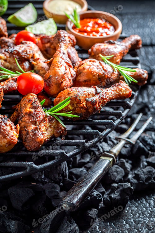 Preview: Closeup of roasted chicken wings with sauces and lime