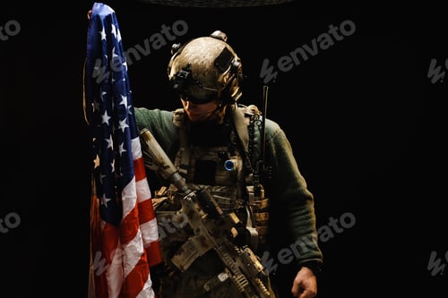 Preview: Special forces soldier holding US national flag in the dark