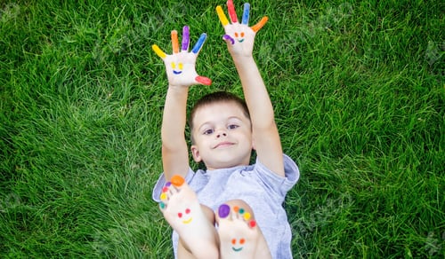 Preview: Children's hands in the colors of summer, a smile on the boy's palm