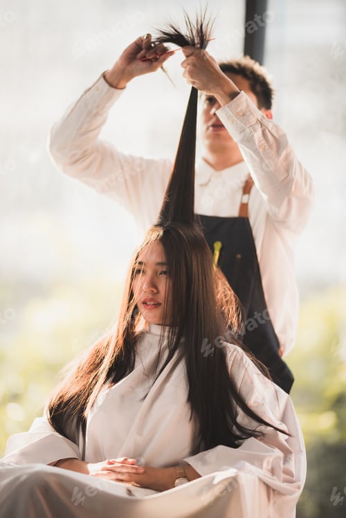 Preview: Hairdresser is cutting long hair in hair salon with scissor