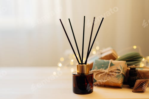 Preview: Home winter aroma fragrance diffuser on wooden table. Interior elements.