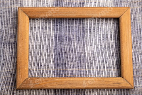 Preview: Wooden frame on smooth brown and violet linen tissue. Top view, natural textile background.
