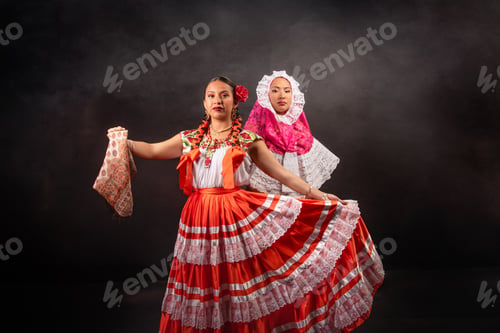 Preview: Two women in traditional Mexican clothing are dancing together