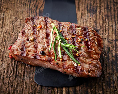Seared Steak Garnished with Rosemary on Wooden Board