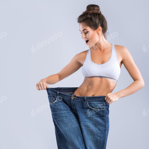 Preview: Happy woman wearing jeans after weight-loss on gray background
