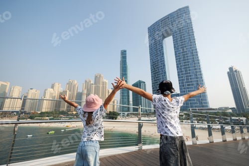 Preview: Two children enjoying the view of the modern city skyline with beach. Dubai Marina.