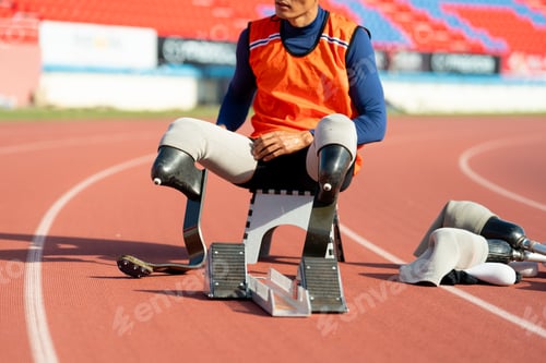 Preview: Asian para-athletes with prosthetic blades sprint on a running track at stadium.