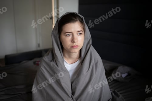 Preview: woman wrapped in a blanket sitting in stylish bed