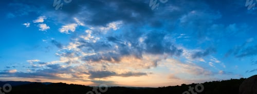 Preview: Breathtaking sky filled with dramatic clouds transitions from deep blue to soft pastels as sun sets