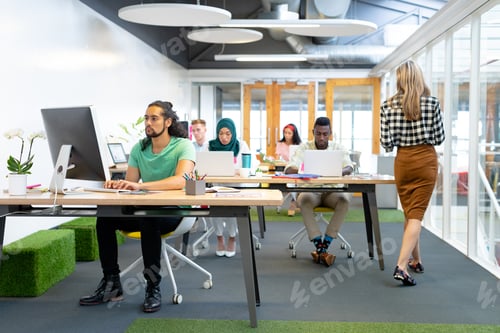 Visualização: Vista frontal de diversos empresários trabalhando na mesa em um escritório moderno