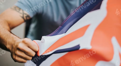 Preview: Man showing his fist with UK flag during a protest