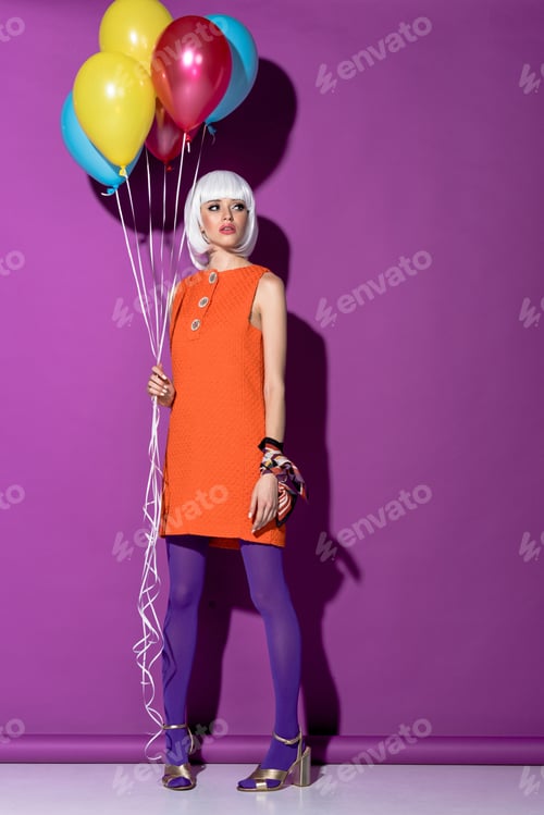 Preview: Full length view of woman in white wig holding air balloons on purple background