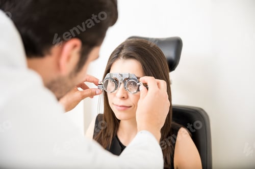 Preview: Beautiful woman doing eye test with trial frame