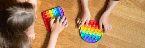 Preview: Children Playing with Colorful Pop It Toys at Home