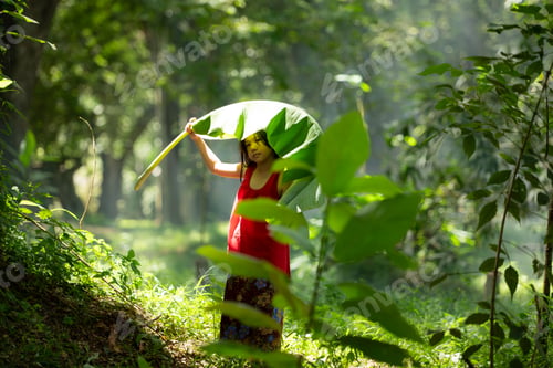 Vista previa: Little asian girl in red dress holding fishing equipment in the forest,