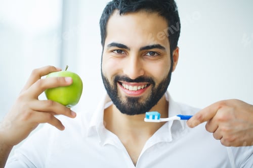 Preview: Man With Apple. Beautiful male With White Smile, Healthy Teeth. High Resolution Image