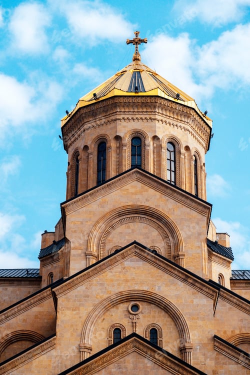 Preview: Part of Tsminda Sameba - Holy Trinity Church in Tbilisi, Georgia on a sunny day against a blue sky.
