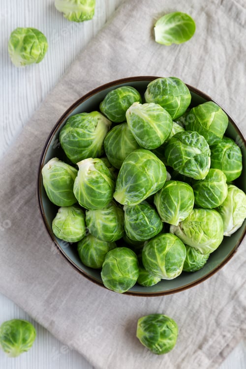 Preview: Raw Organic Brussel Sprouts in a Bowl, top view. Flat lay, overhead, from above.