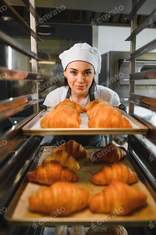 Preview: Baker taking freshly baked croissants out of oven