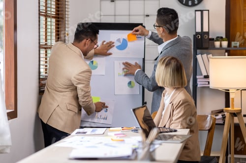 Preview: Group of confident business people point to graphs and charts to analyze market data, balance sheet,