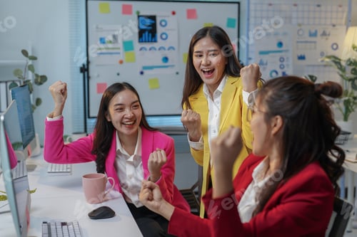 Preview: Three joyful businesswomen are raising their fists in celebration, expressing their excitement over