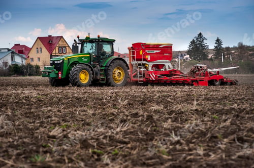 Preview: Farmers sow, apply fertilizer using tractor with a seeder in a plowed field