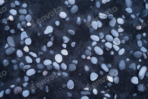 Preview: Gray pebbles and black sand as a background. Round stones on the beach.