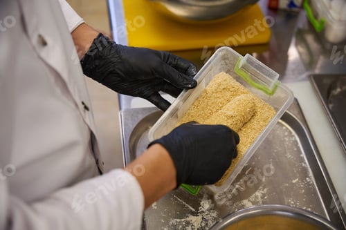 Preview: Man breads a Kiev cutlet in breadcrumbs
