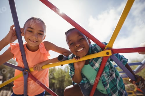 Preview: Portrait of happy schoolkids looking through dome climber
