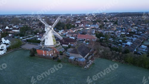 Preview: Large windmill in a cityscape, surrounded by urban buildings and nearby fields
