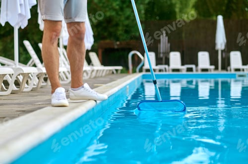 Preview: A service person cleaning the swimming pool and looking busy