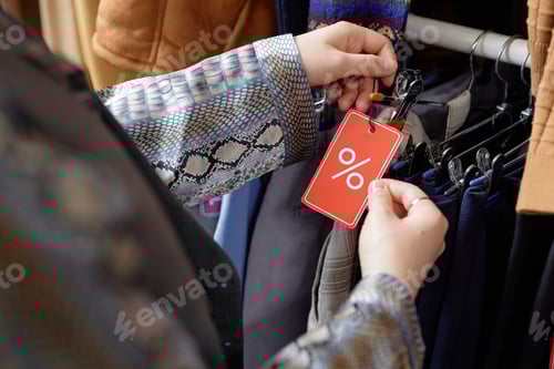 Preview: Hands of Shopper Choosing Clothes at Discounted Price