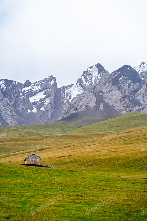 Preview: Remote mountain dwelling in a vibrant green landscape