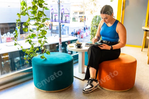 Preview: Designer working with a tablet at coffee shop