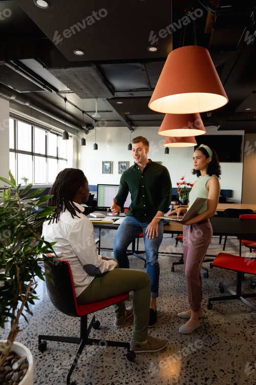 Preview: Caucasian manager discussing with colleague in meeting at creative office