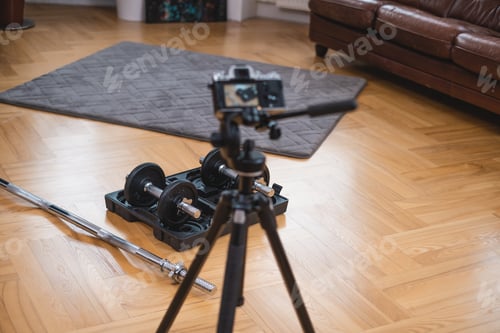 Preview: Photocamera shoots professional sports equipment on floor in room