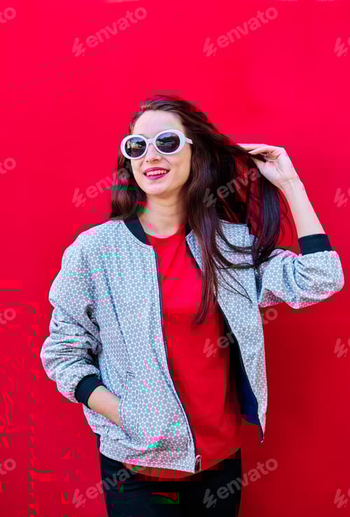Preview: Stylish Woman Posing With Sunglasses Against Red Background