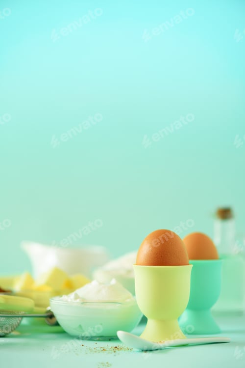 Preview: Healthy baking ingredients - butter, sugar, flour, eggs, oil, spoon, brush, whisk, milk over blue