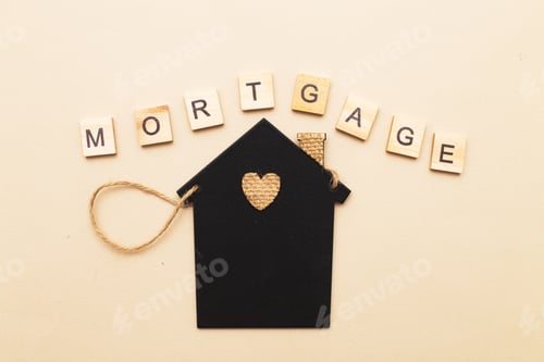 Preview: inscription mortgage with a little house on a beige background made by wooden blocks