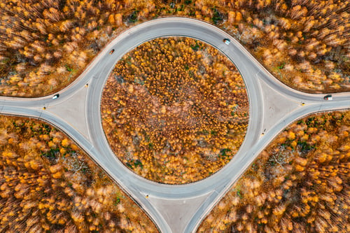 Preview: Aerial view of a traffic roundabout and road junctions with cats in fall autumn color trees forest