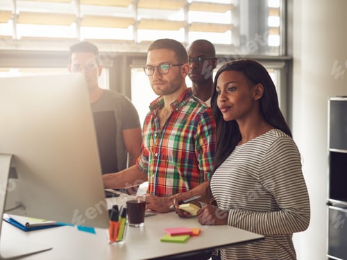 Preview: Four diverse workers standing next to computer