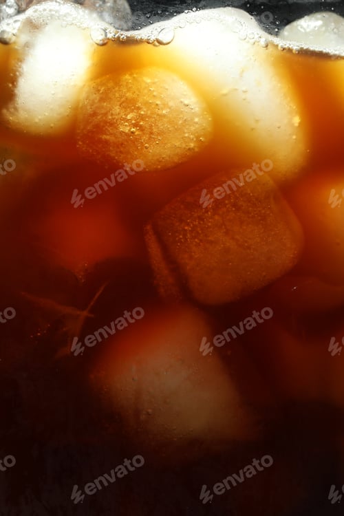 Preview: Refreshing coffee with ice cubes as background, closeup
