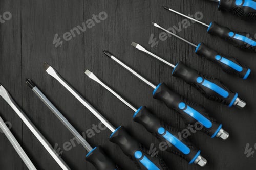 Preview: Set of screwdrivers on black wooden table, top view