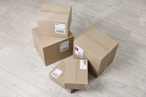 Preview: Cardboard parcel boxes with shipping labels on floor indoors