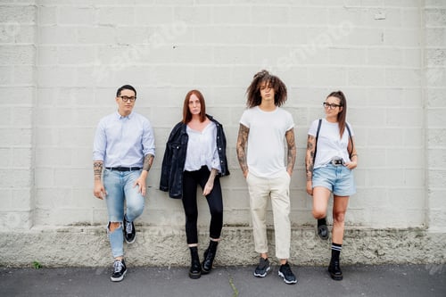 Preview: Four friends posing confidently against a white brick wall